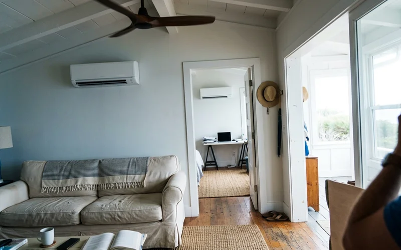 Two mini-split indoor heads in adjoining rooms of a multi-zone setup
