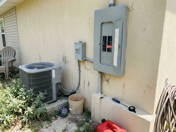 AC disconnect box on a stucco wall beside a Gulf Shores rental