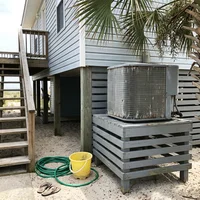 Salt-weathered outdoor AC condenser beside a raised Gulf Shores beach house